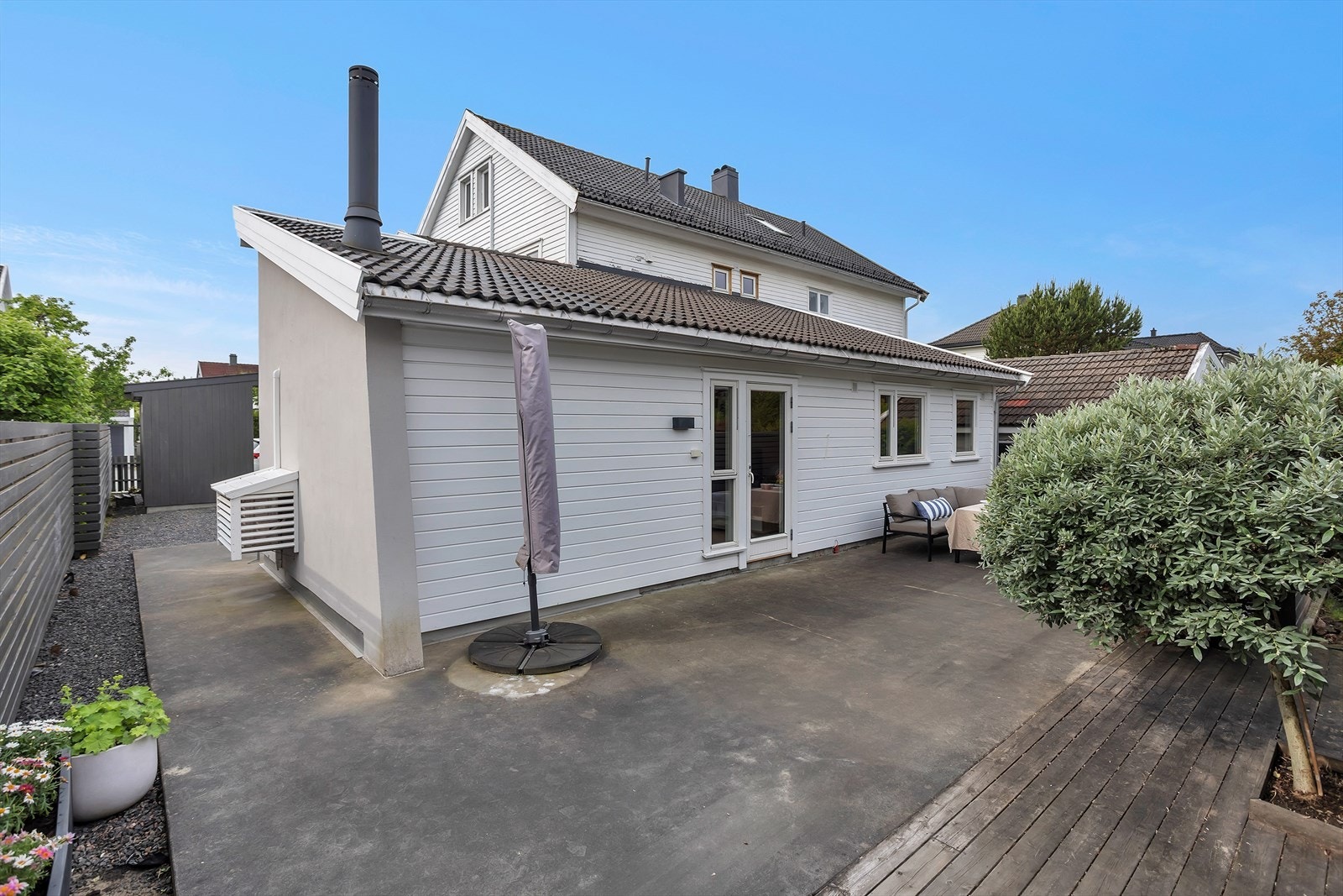 Oversikt over den store uteplassen og leilighetens fasade. Galleribilde