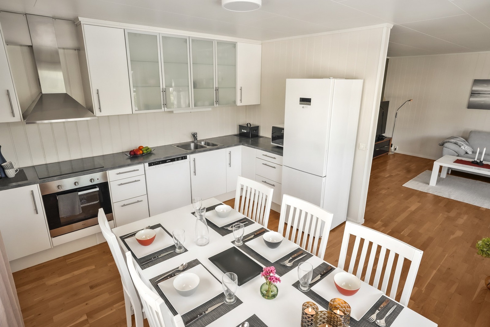 Kjøkkeninnredning med hvite, profilerte fronter og laminat benkeplate. Galleribilde