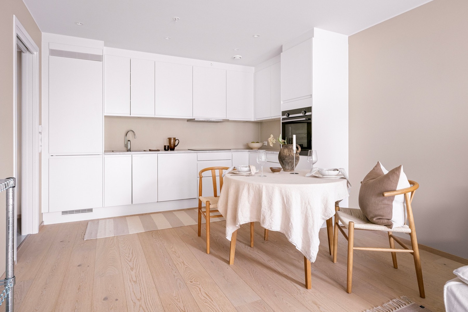 Kjøkkenet er fra Sigdal og har et stilrent og tidløst uttrykk med hvite, slette fronter, laminatbenkeplate og integrerte hvitevarer. Galleribilde