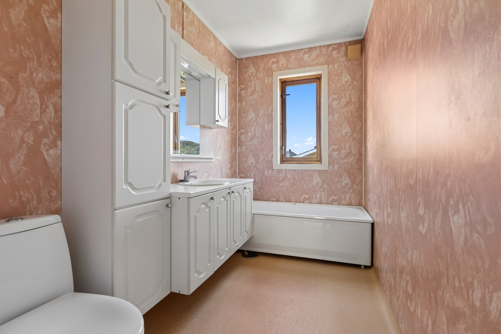 Badet er utstyrt med badekar, servant med underskap og toalett. Galleribilde