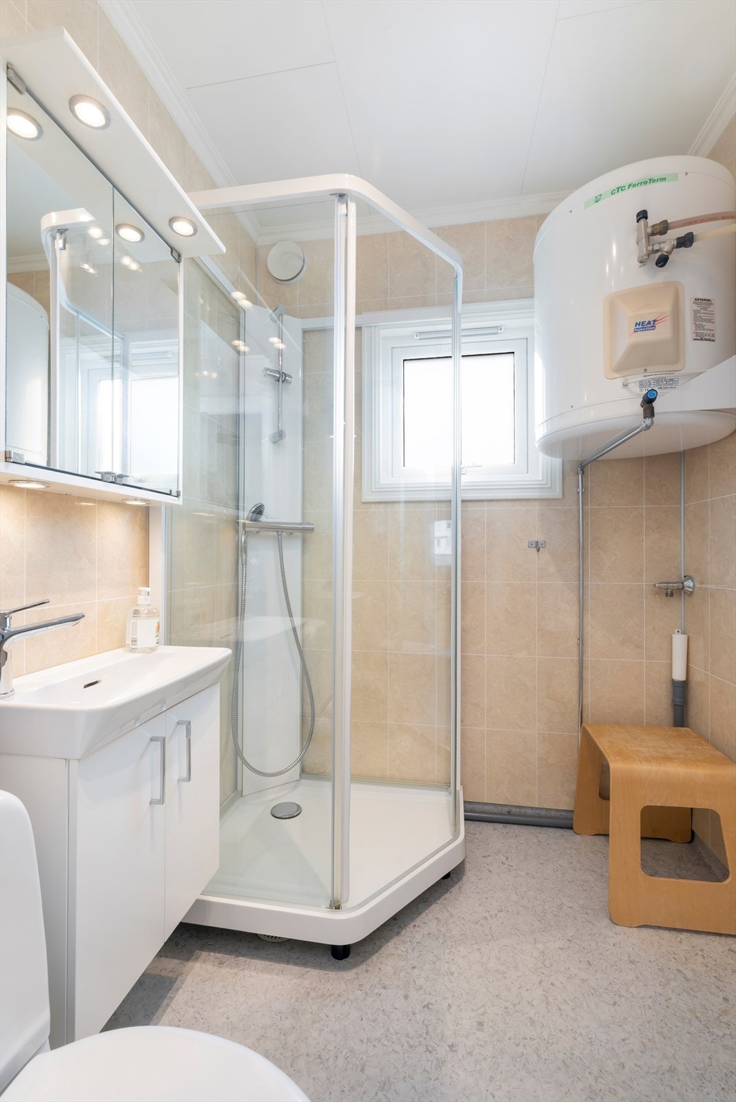 Badet har wc, servant med skap, dusjkabinett og opplegg vaskemaskin Galleribilde