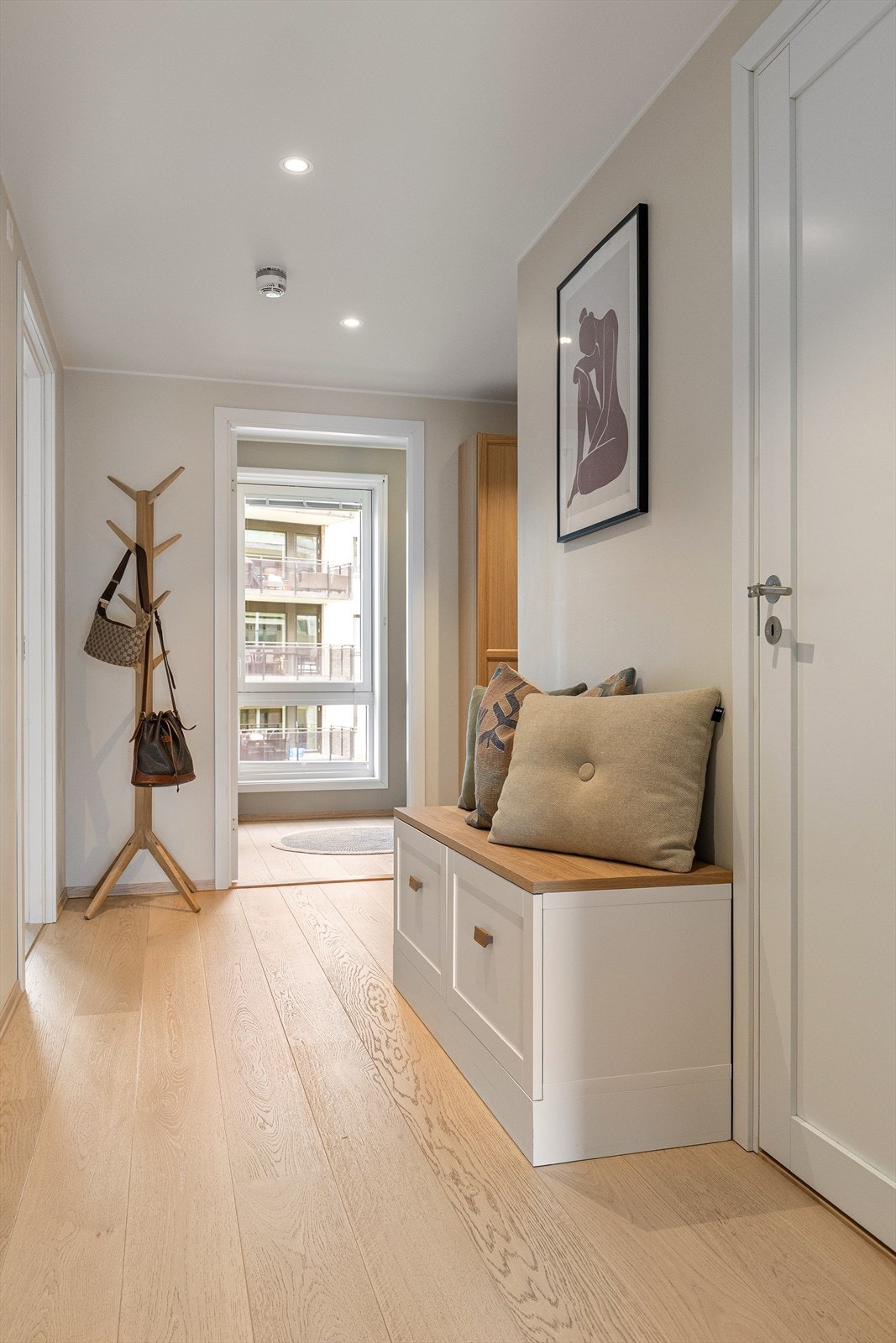 Leiligheten har en lys og åpen entré som gir et umiddelbart godt førsteinntrykk. Her er det god plass til å henge fra seg yttertøy og sko i påkostet, plassbygget skyvedørsgarderobe. Galleribilde