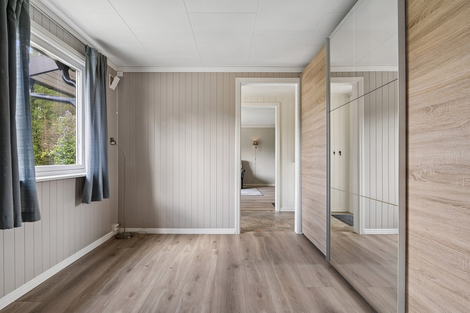 I mellomstuen er det montert en stor skyvedørsgarderobe med speilfronter. Galleribilde