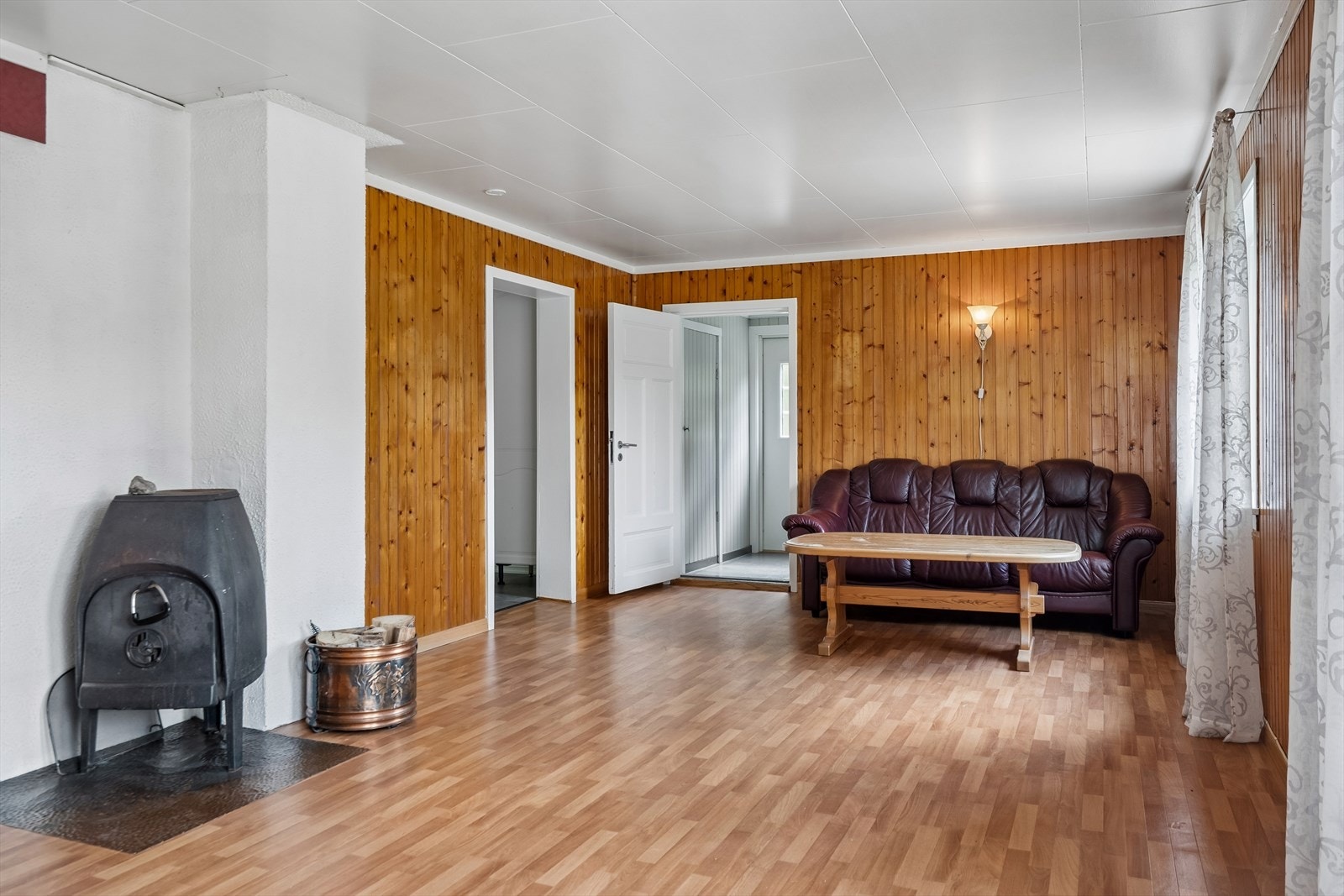 Rommet har vegger med trepanel og laminat på gulvet. Galleribilde