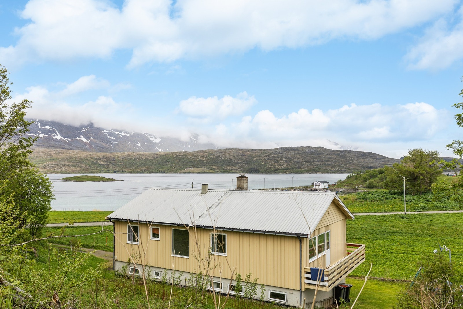 Eiendommen ligger fritt til med utsikt mot sjøen og de omkringliggende fjellene ca 2 minutters kjøring fra brua. Galleribilde
