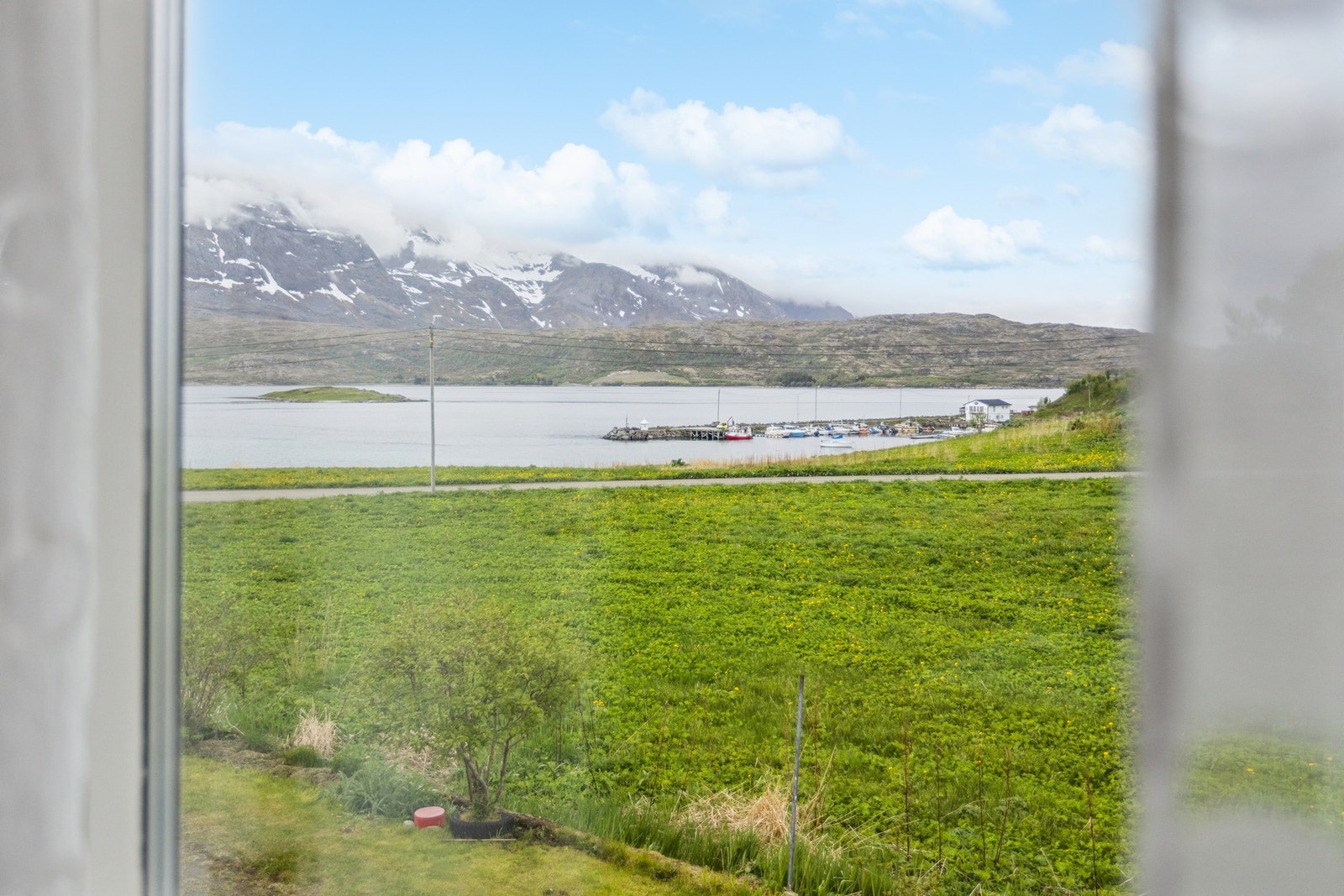 Fra boligen har man utsikt mot småbåthavnen og fjellene i horisonten. Galleribilde