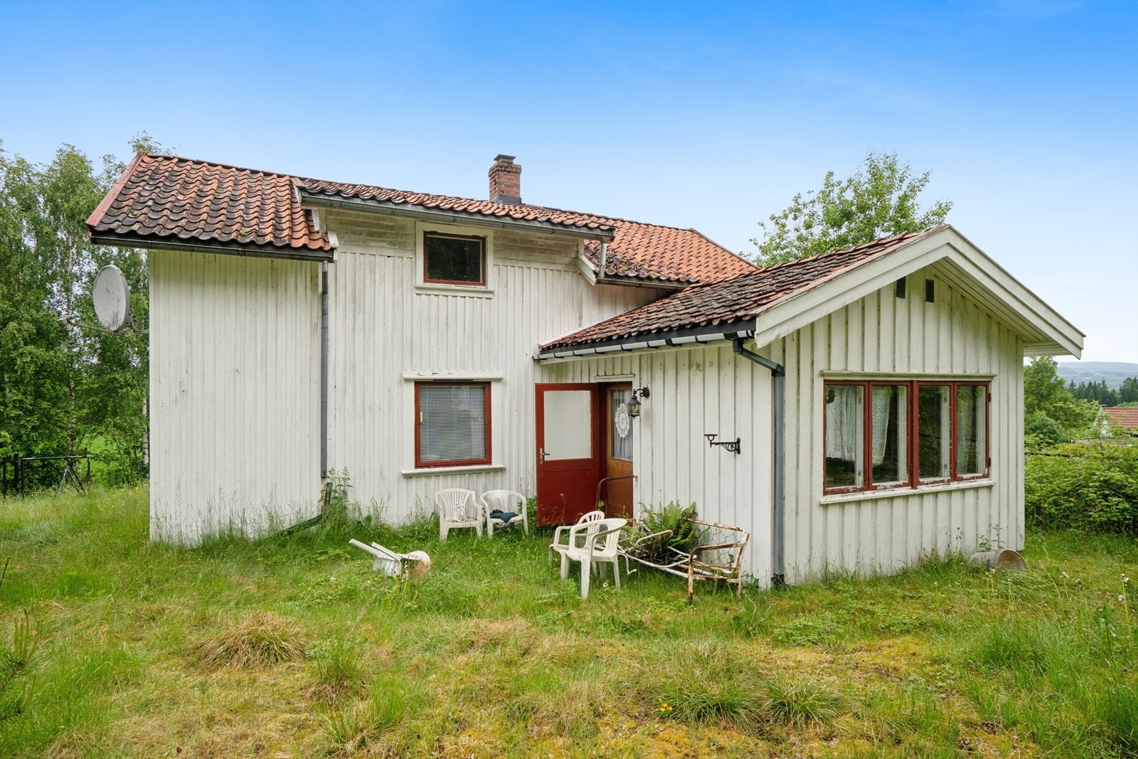 Fasaden har stående bordkledning og vinduer med sprosser. Galleribilde