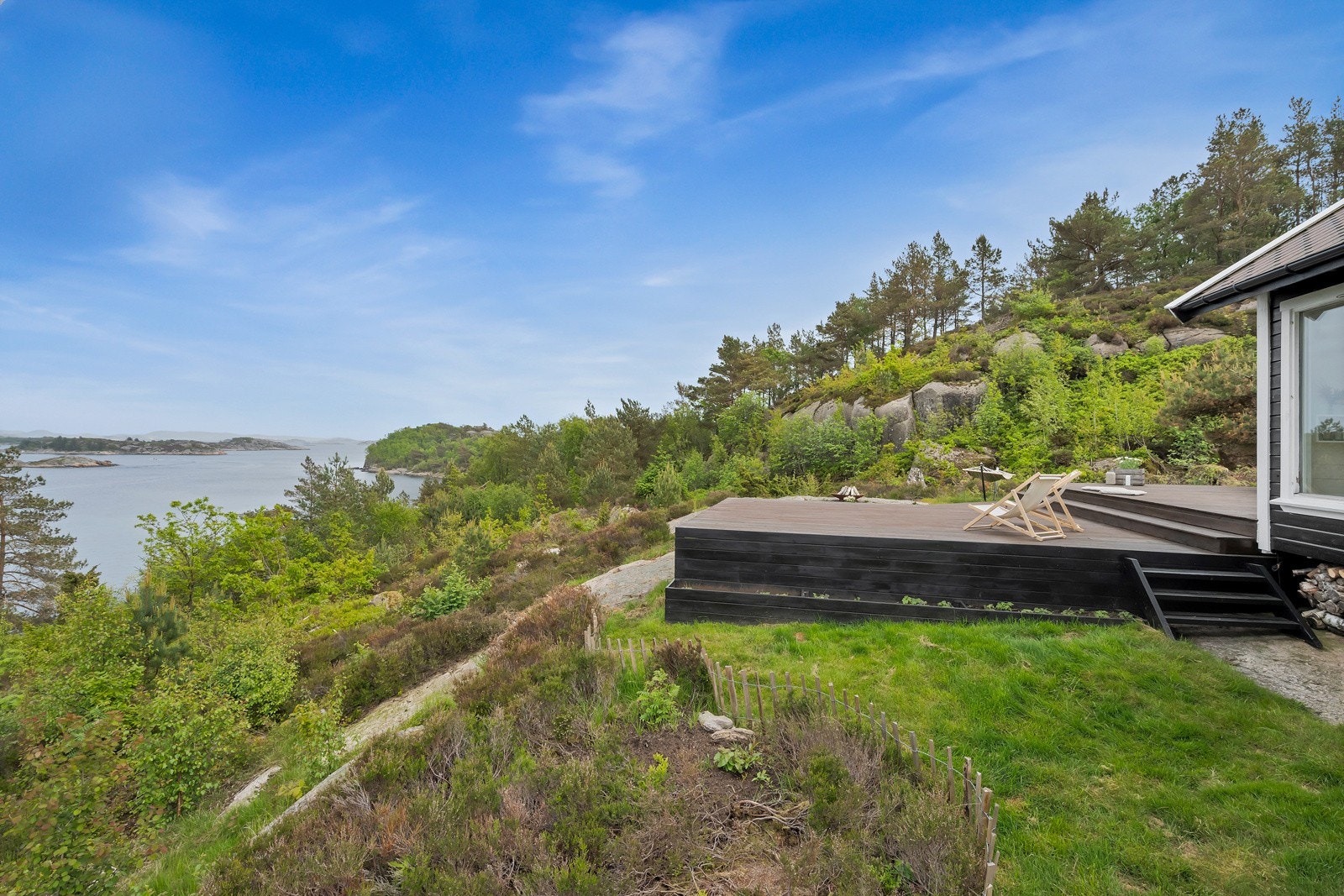 Fra terrassen går det trapp ned til plenområde og bed med høstanemoner. Galleribilde