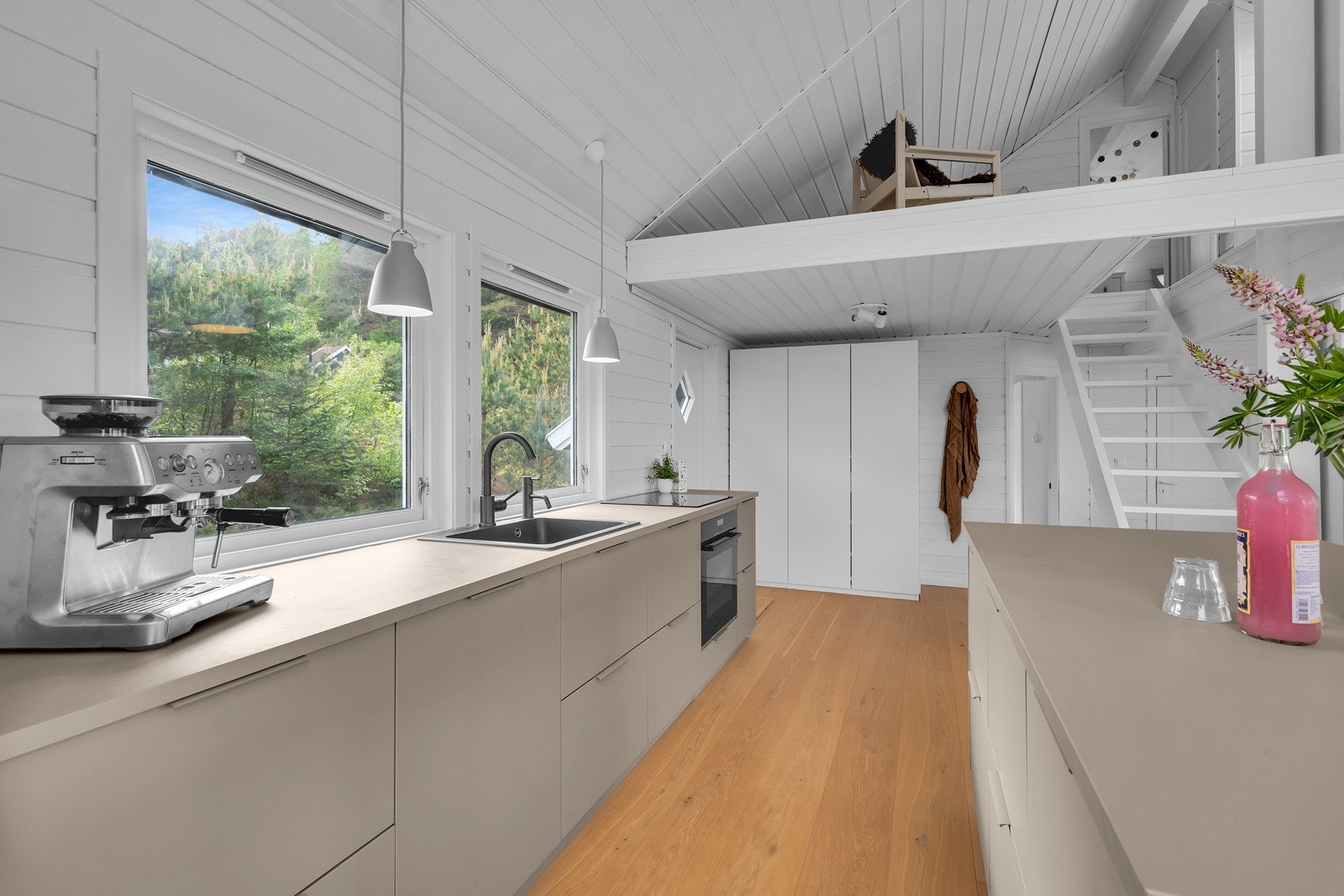 Kjøkkenet har integrert stekeovn og koketopp i sort design samt Blanco kjøkkenvask og armatur i brunt (bronze). Galleribilde