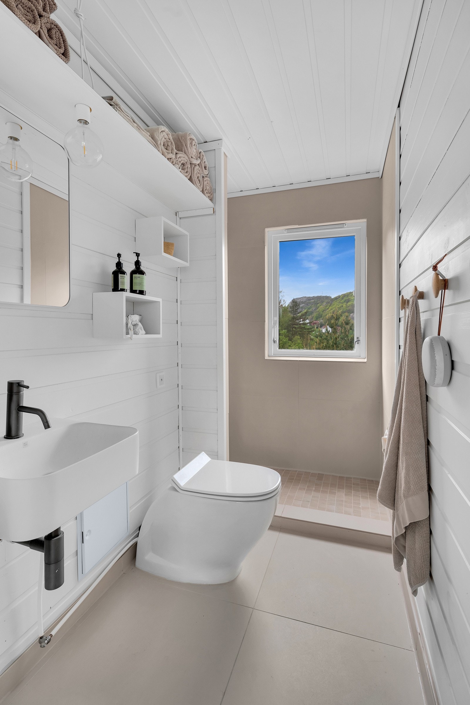 Lyst og pent bad med moderne vakuumtoalett. Galleribilde