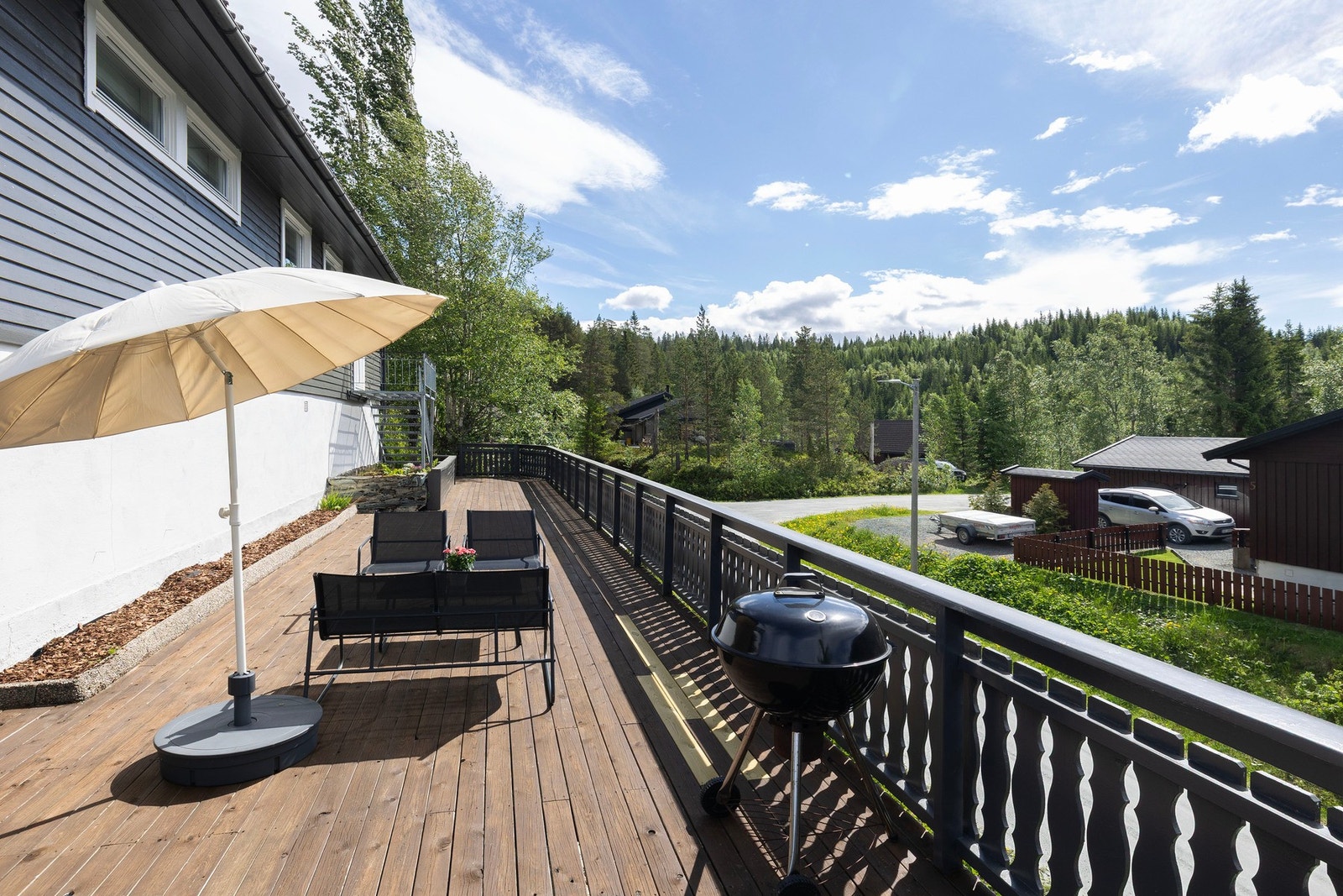 Langstrakt terrasse med flere soner for avslapning og sosiale sammenkomster. Galleribilde