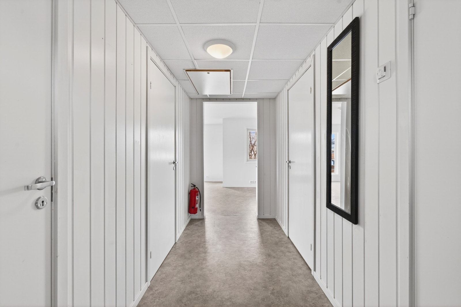 Gjennomgående gulvbelegg og lyse, malte veggplater gir et helhetlig inntrykk. Herfra er det åpen tilgang til stue og kjøkken. Galleribilde