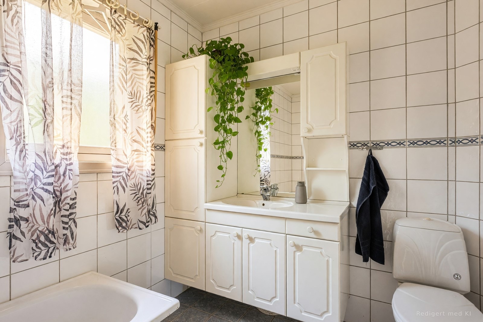 Badet i første etasje ble pusset opp i 2007 og har flislagte overflater og innredning med nedfelt servant. (Bildet er redigert med KI) Galleribilde