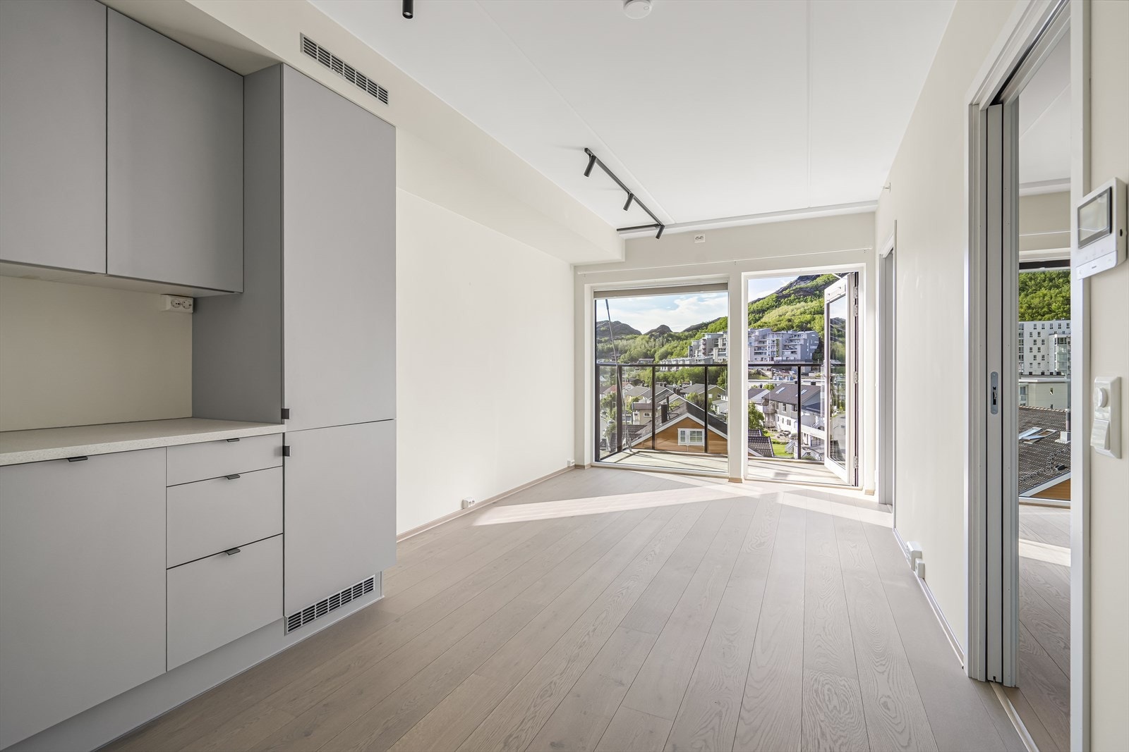 Kjøkkenet ligger i moderne åpen løsning og har en stilren innredning med slette malte fronter og laminert benkeplate med nedfelt komposittvask. Galleribilde