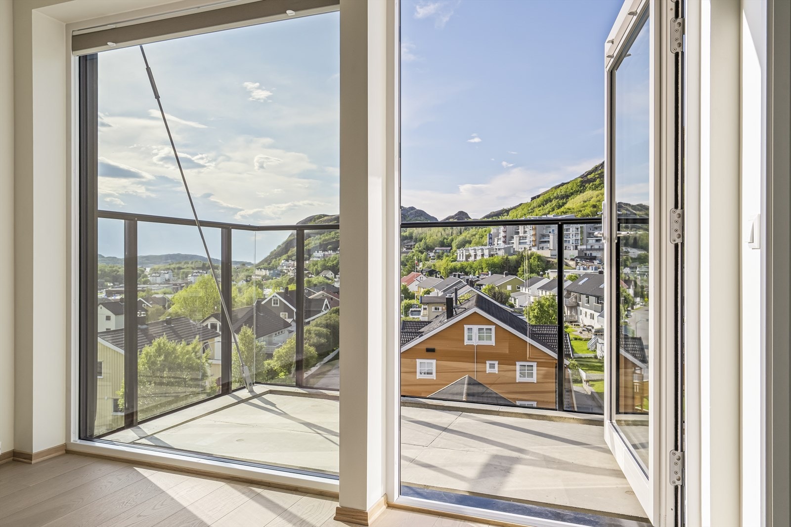 Utgang fra stuen til en nordvest-vendt balkong m/glassrekkverk. Galleribilde