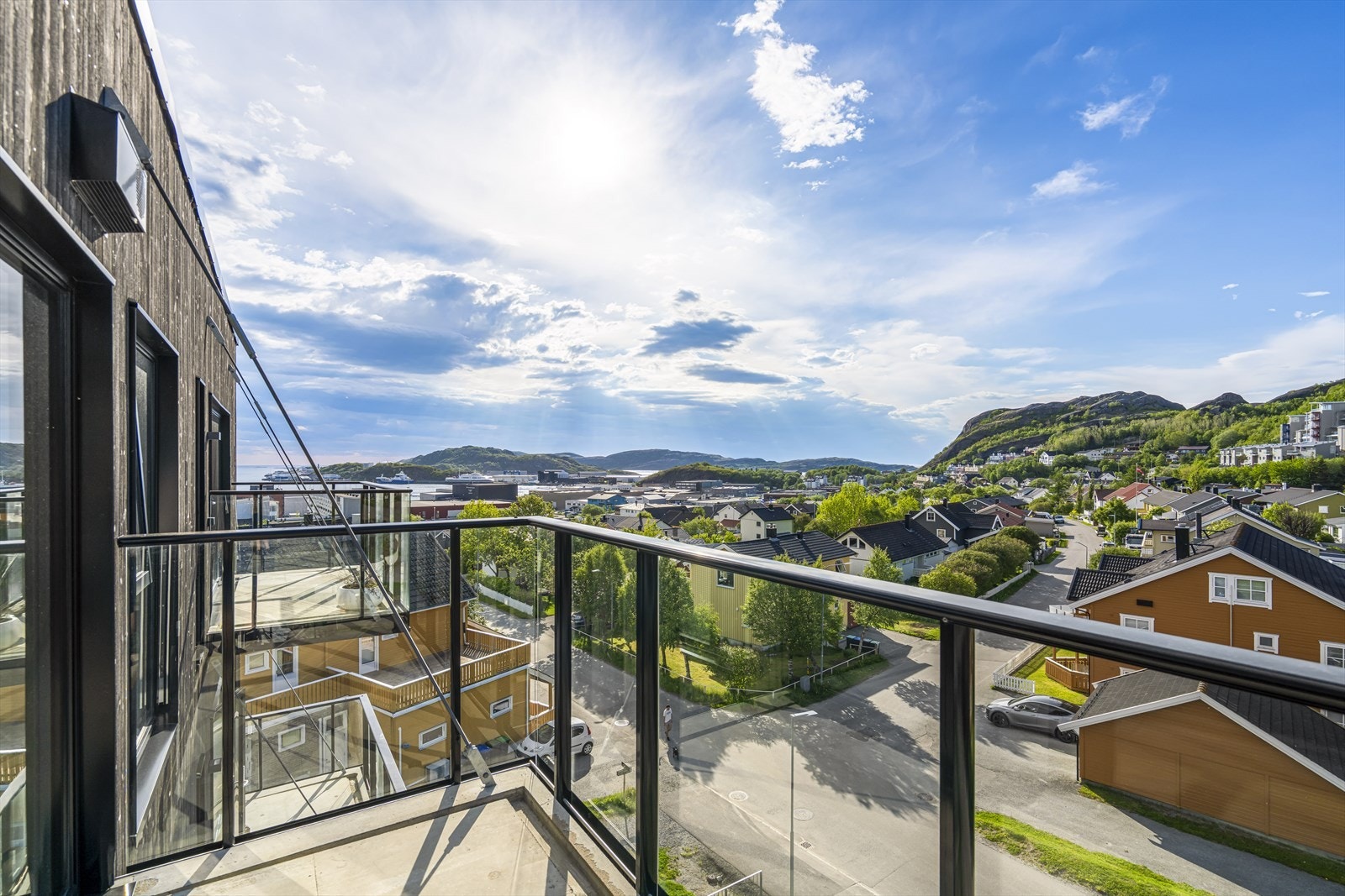 Balkongen har rekkverk i glass og det er belysning og utestikk. Galleribilde