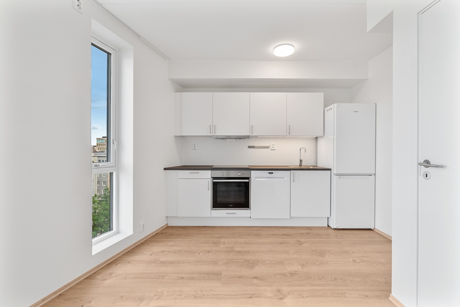 Kjøkkenet har innredning med hvite, slette fronter som gir et minimalistisk og stilrent uttrykk. Galleribilde