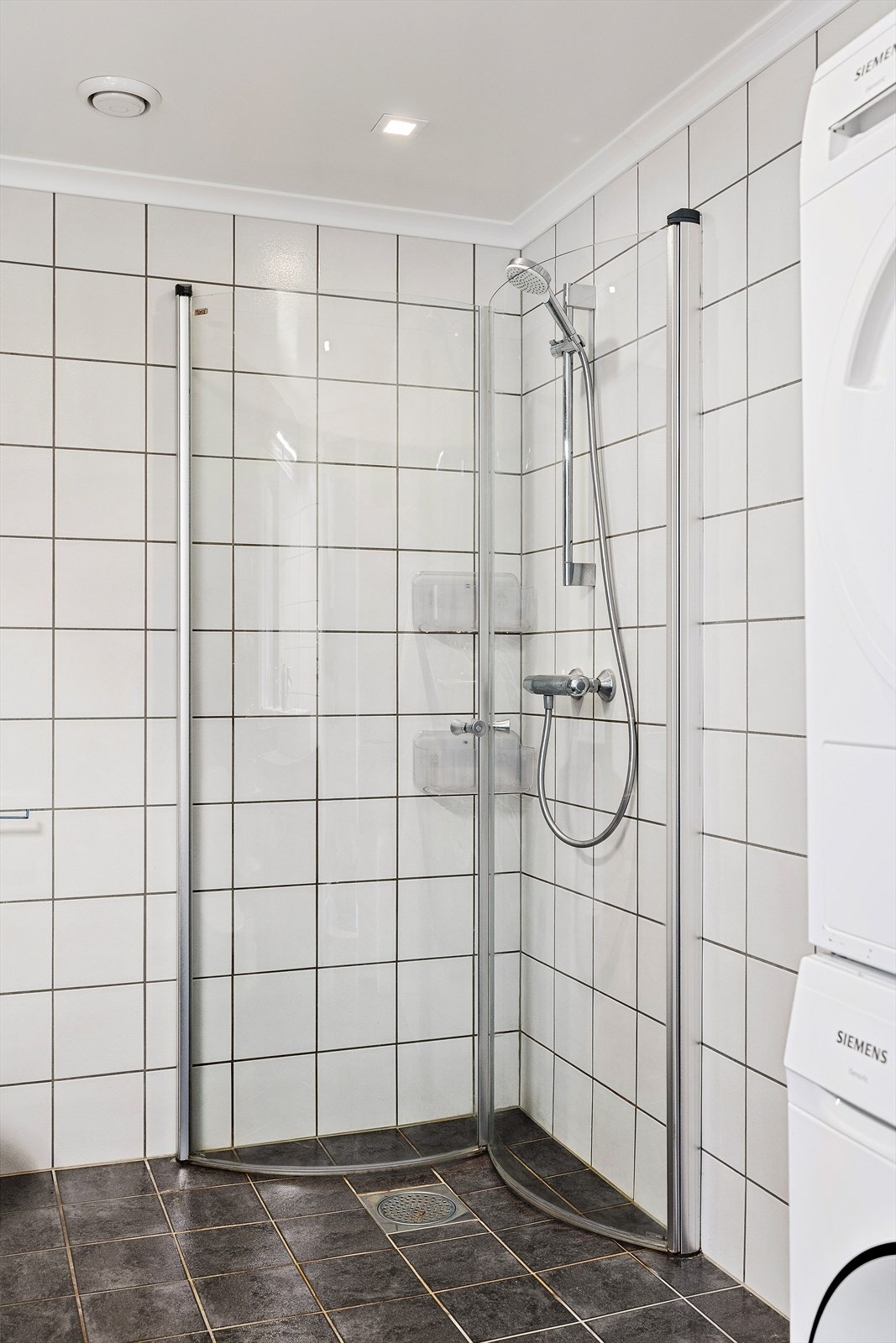Dusjnisjen har innfellbare glassvegger og dusjgarnityr på veggen. Galleribilde