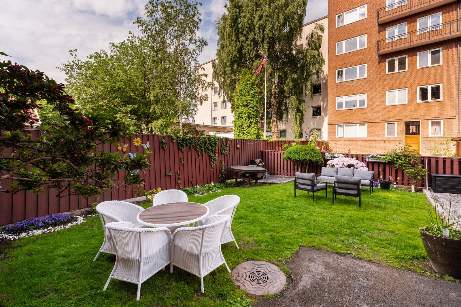 Felles bakgård med utemøblement, grill og planter. Galleribilde