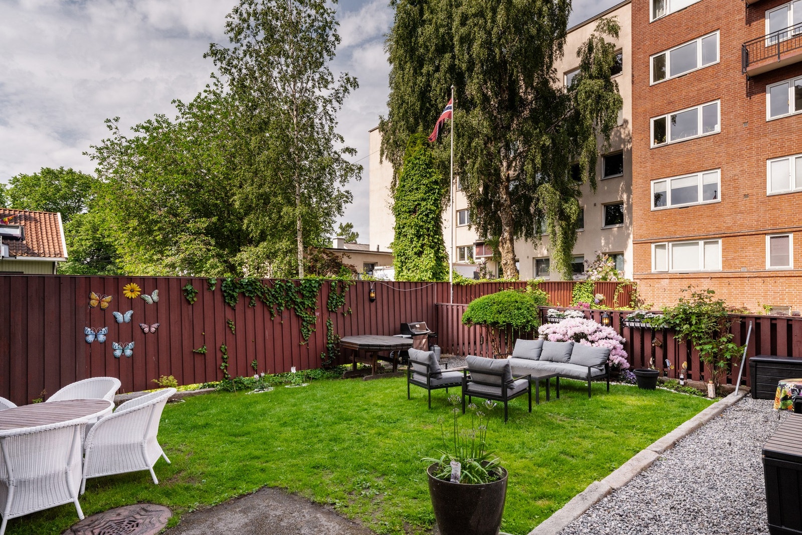 Felles bakgård med utemøblement, grill og planter. Galleribilde
