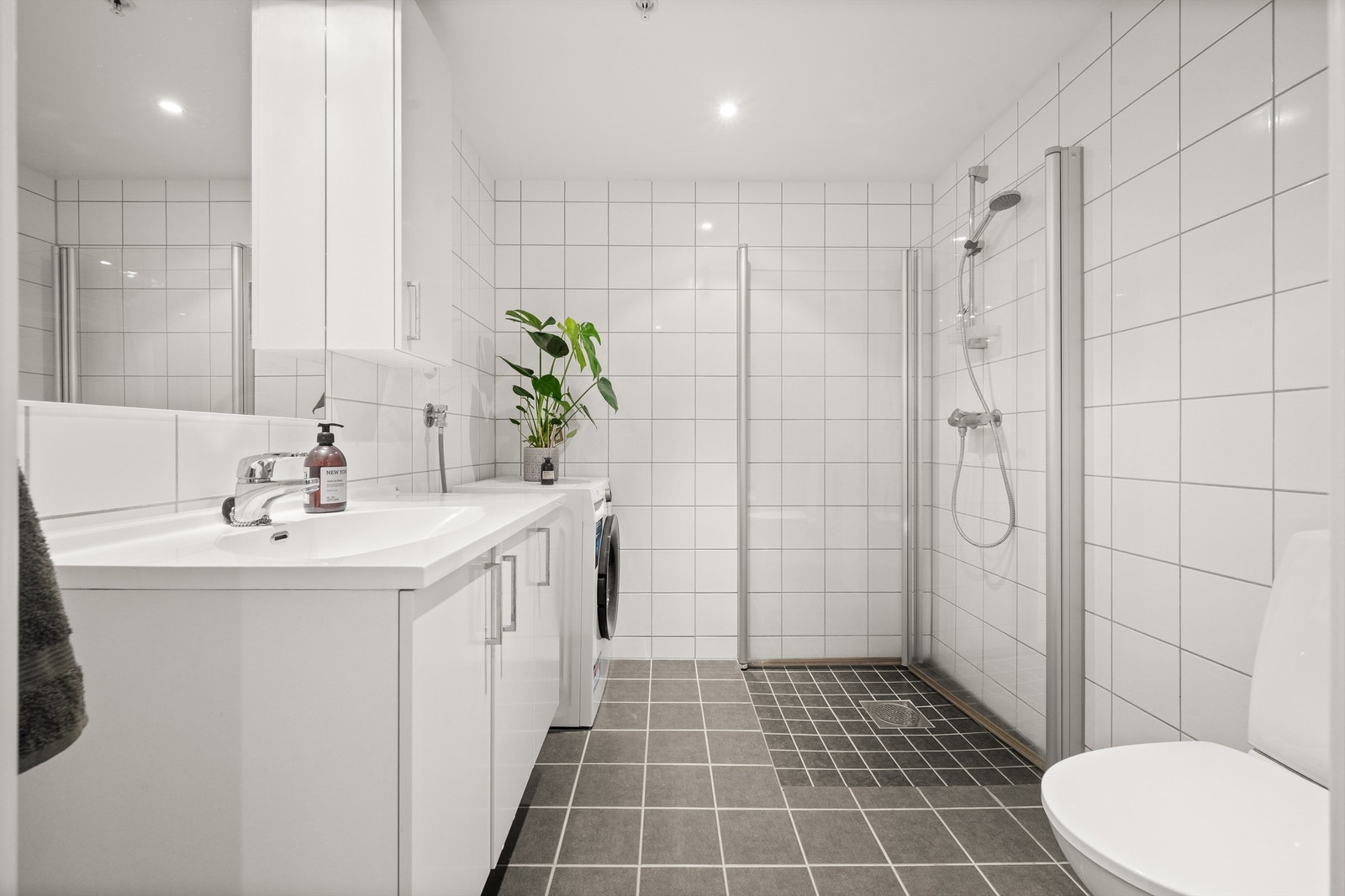 Stort, flislagt bad med elektrisk gulvvarme og downlights. Galleribilde