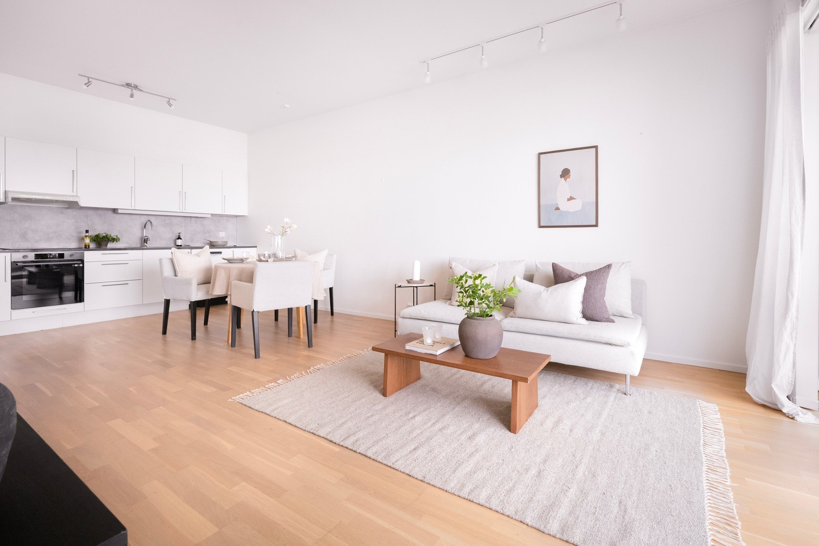 Stuen har plass til både sofagruppe, tv-løsning og spisebord, og den åpne løsningen mot kjøkkenet gjør stuen til boligens naturlige samlingspunkt. Galleribilde