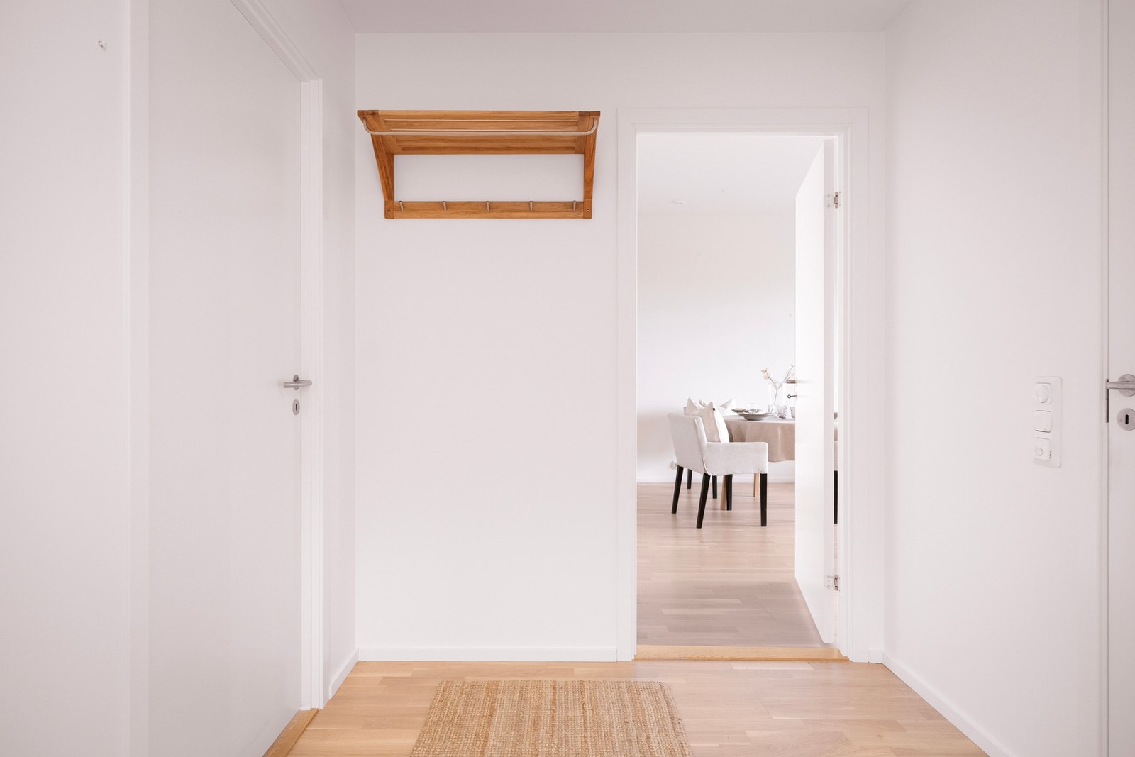 Entréen gir et lyst og ryddig førsteinntrykk, med hvite vegger, parkettgulv og plass til oppheng for yttertøy. Galleribilde