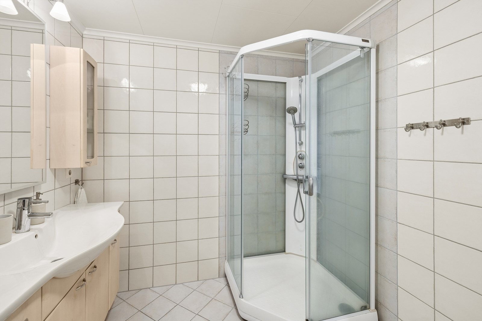 Dette badet er også utstyrt med dusjkabinett, servantinnredning og vegghengt toalett. Galleribilde