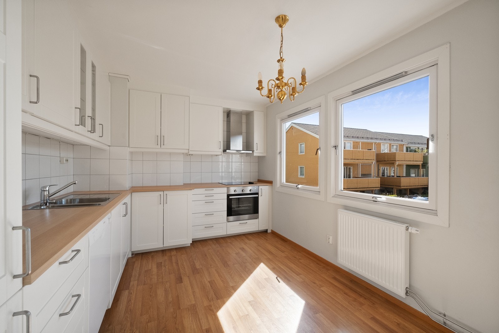 Hvit kjøkkeninnredning med mye skap- og benkeplass. Galleribilde
