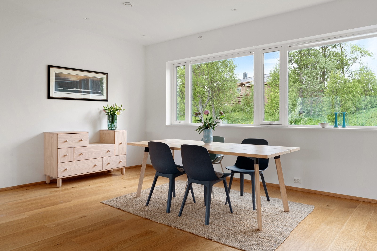 Lyset fra vinduene gjør spiseplassen til et naturlig midtpunkt, både til hverdags og når huset fylles av gjester.
