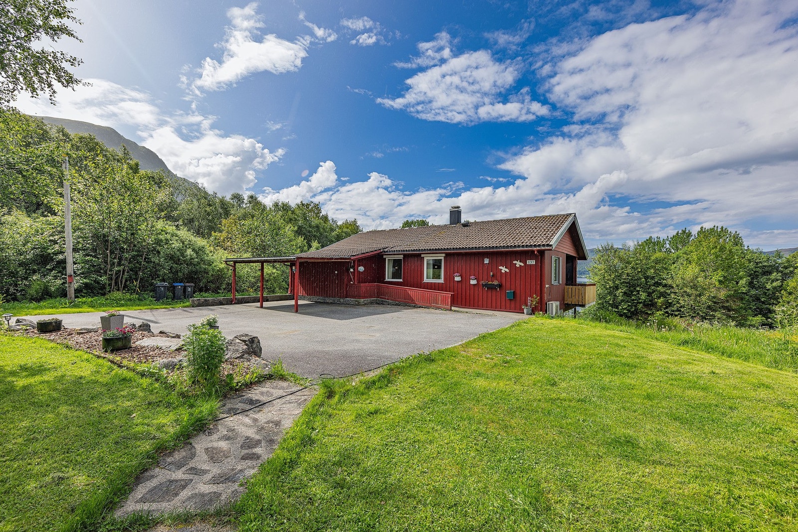 Velhalden og innhaldsrik einebustad med carport ved inngangspartiet Galleribilde