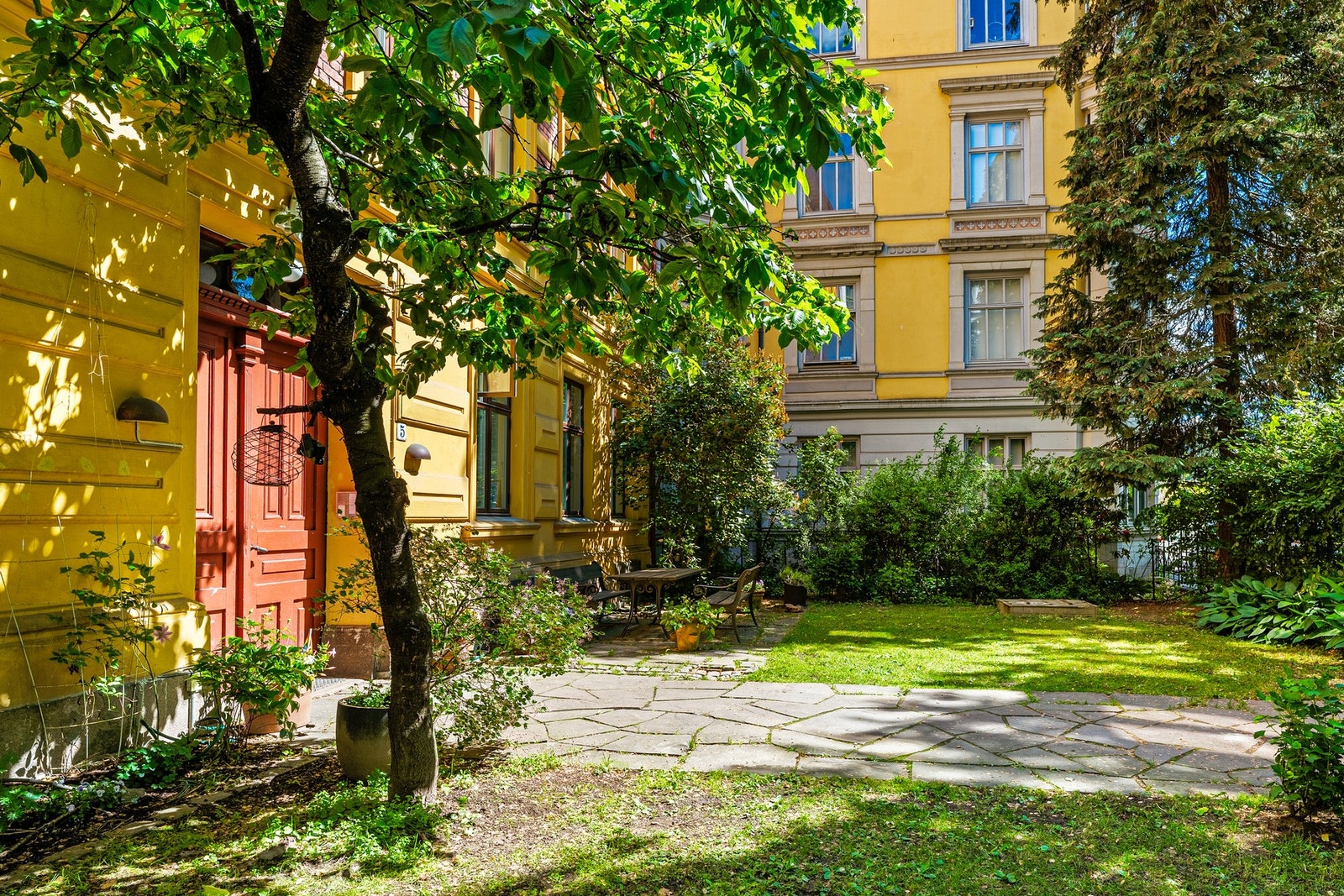 Fasaden er tilbaketrukket fra gata og har flott beplantning og sittegruppe for beboerne Galleribilde