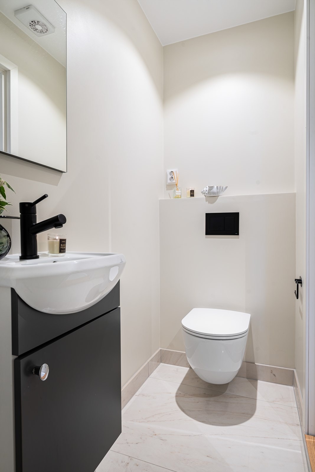 Toalettrommet er bygget opp i samme stil og kvalitet som hovedbadet, med flislagt gulv og behagelige varmekabler som gir en lun og eksklusiv følelse. Galleribilde