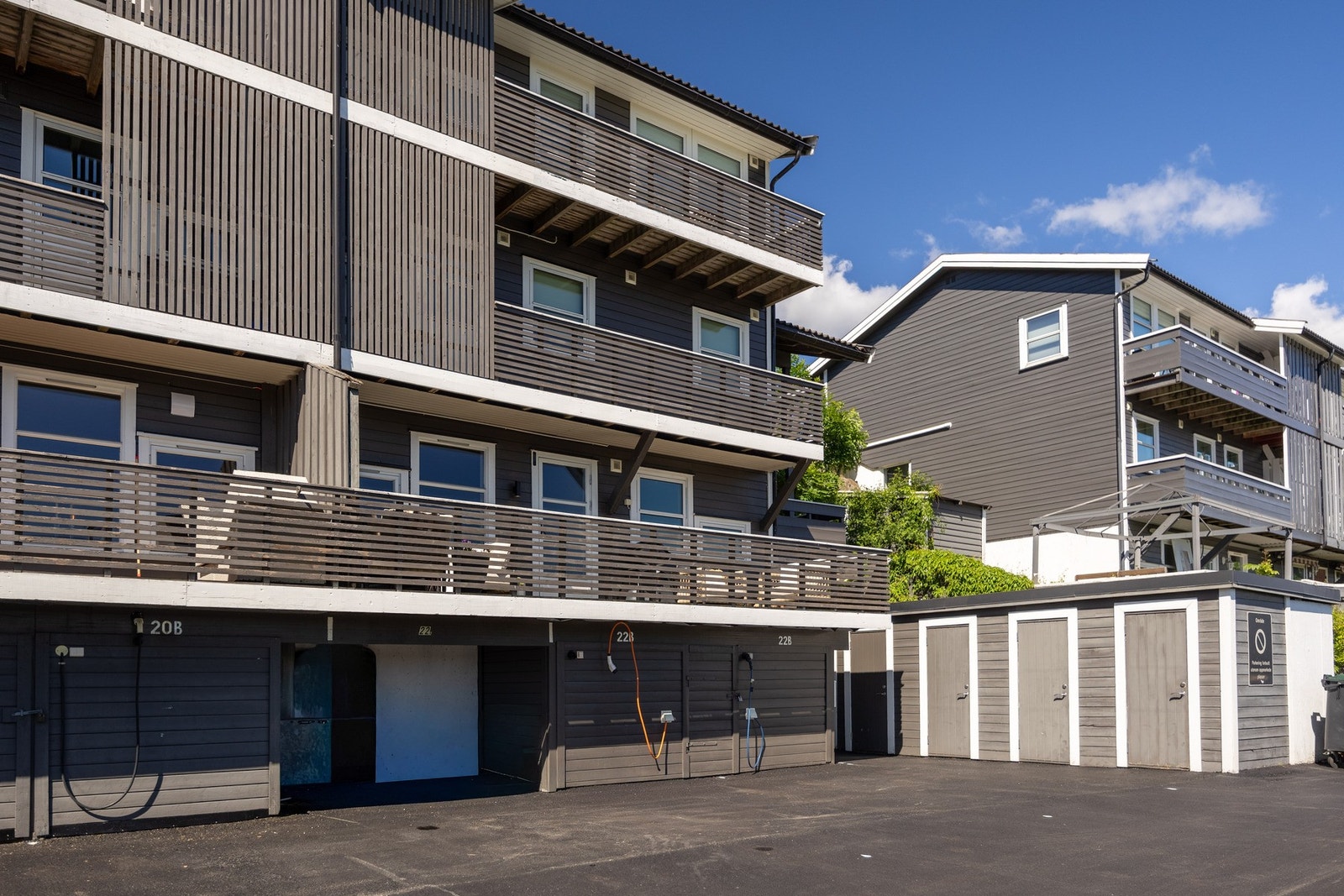 Til boligen følger egen parkeringsplass med elbillader, praktisk plassert i umiddelbar nærhet til inngangspartiet. Uteboden er til høyre for p-plassen. Galleribilde