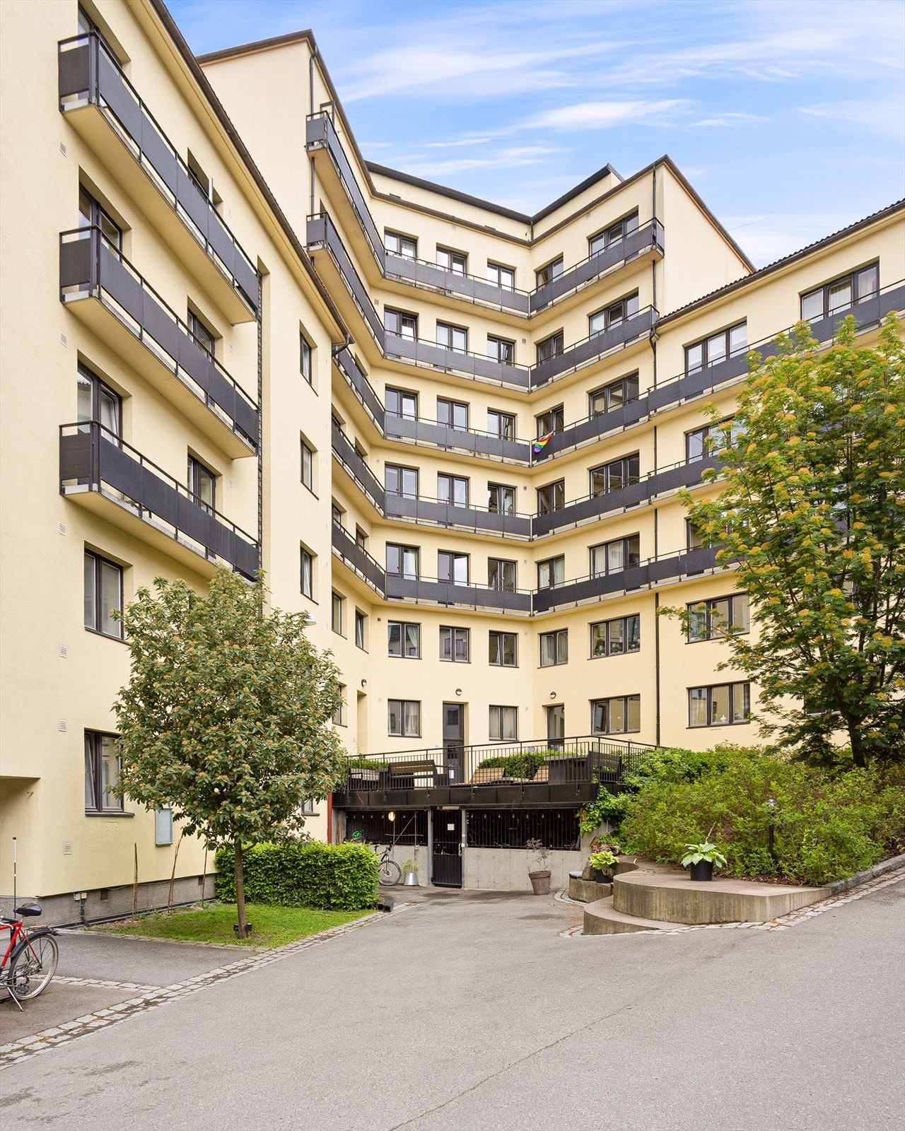 Hyggelig og opparbeidet bakgård med sitteplasser, plen, busker, trær og sykkelparkering Galleribilde