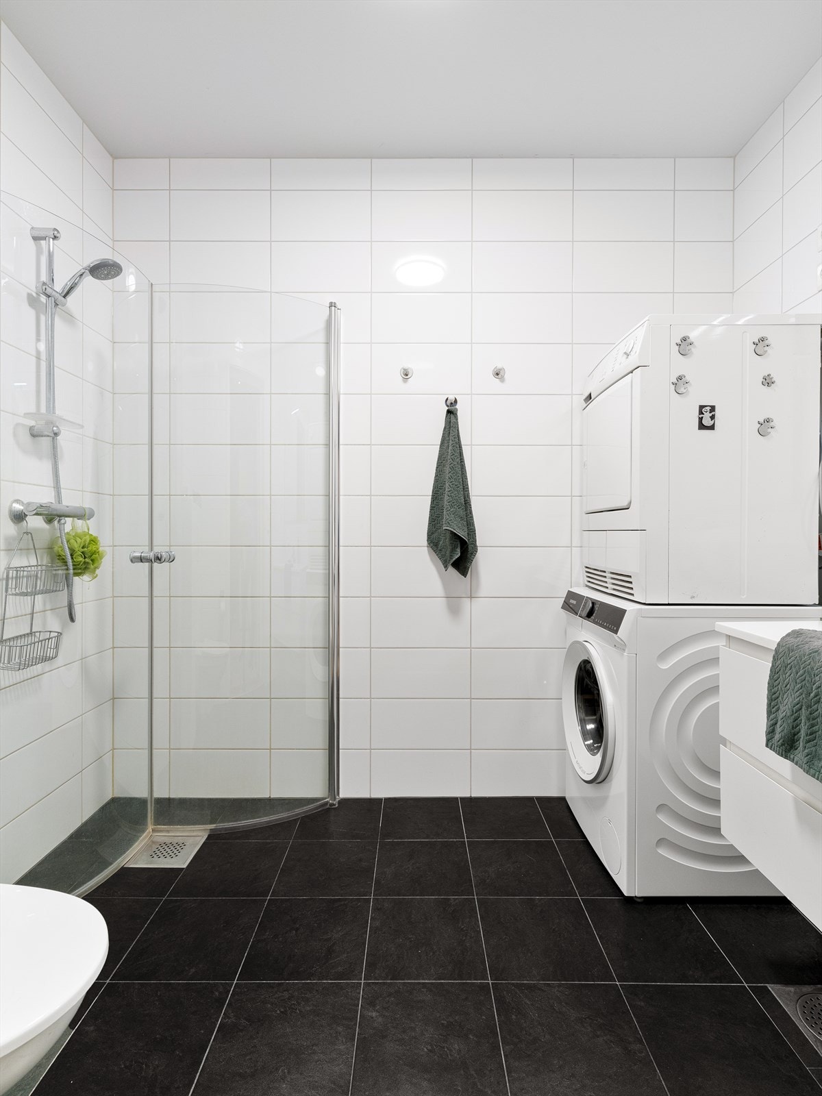 Badet er utstyrt med dusjhjørne, vegghengt toalett og servantinnredning. Galleribilde