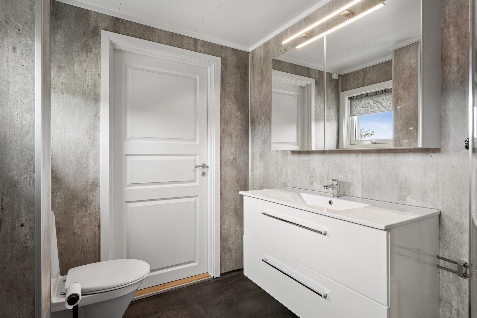 Badet har innredning med nedfelt servant, speilskap med belysning og vinylbelegg med elektriske varmekabler. Galleribilde