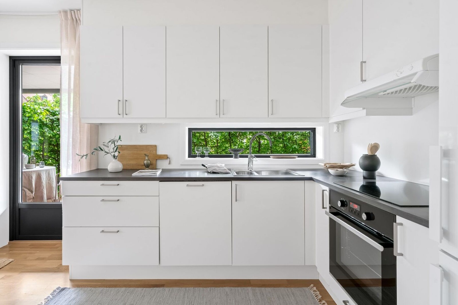 Kjøkkenet fremstår stilrent og funksjonelt med godt med skapplass og en innredning som passer perfekt inn i boligens moderne uttrykk. Galleribilde