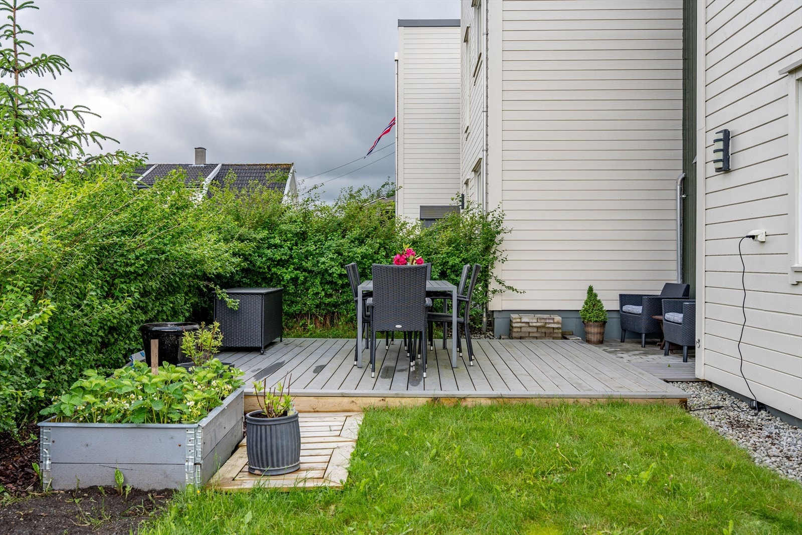 Hagen er pent opparbeidet med plen, busker og pallekarmer for dyrking. Galleribilde