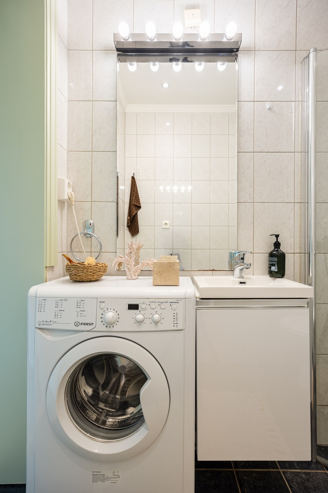 Badet har servantinnredning og opplegg for vaskemaskin Galleribilde