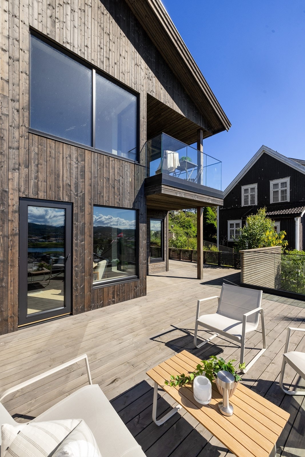 Kombinasjonen av betong, treverk og glass gir denne eiendommen et moderne og lekkert uttrykk. Galleribilde