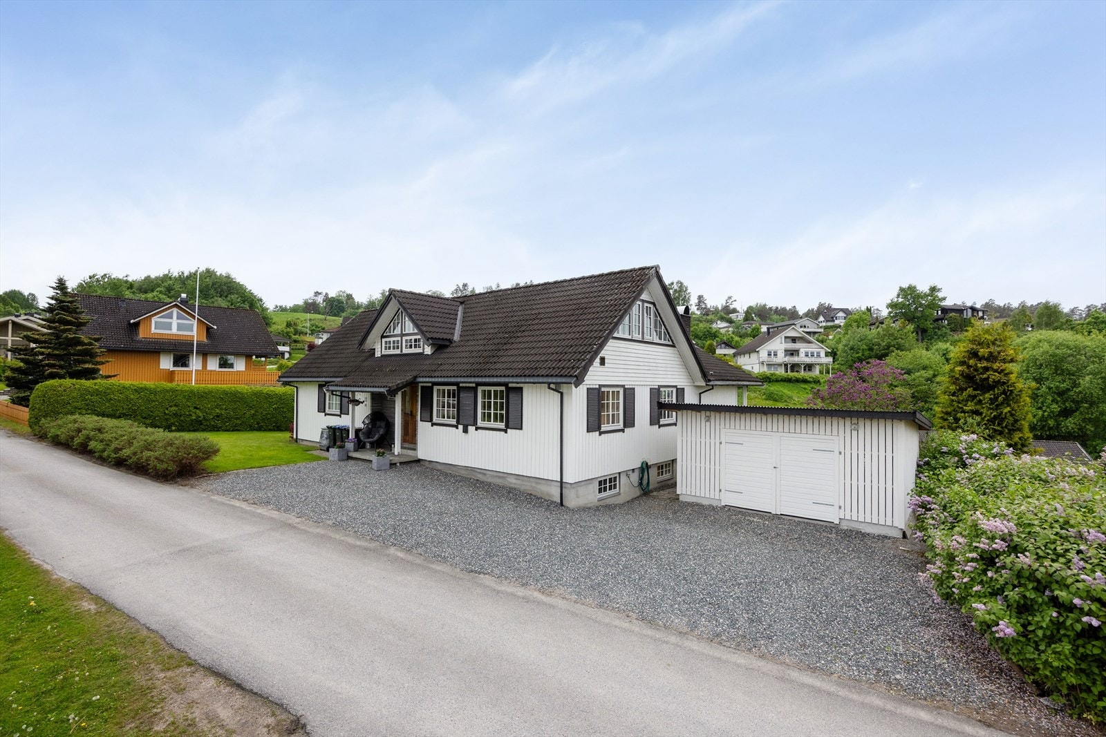 Stor, gruset gårdsplass med rikelig med biloppstillingsplasser i tillegg til dobbelgarasjen. Galleribilde