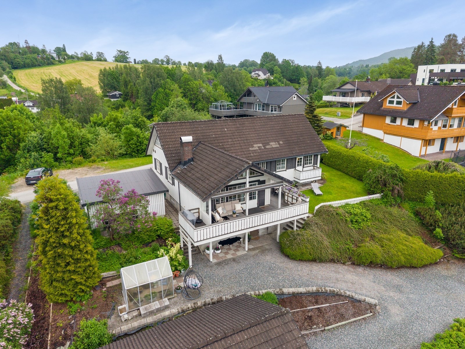 Eiendommen er rikt beplantet og opparbeidet med flere uteplasser, garasje og uthus. Galleribilde