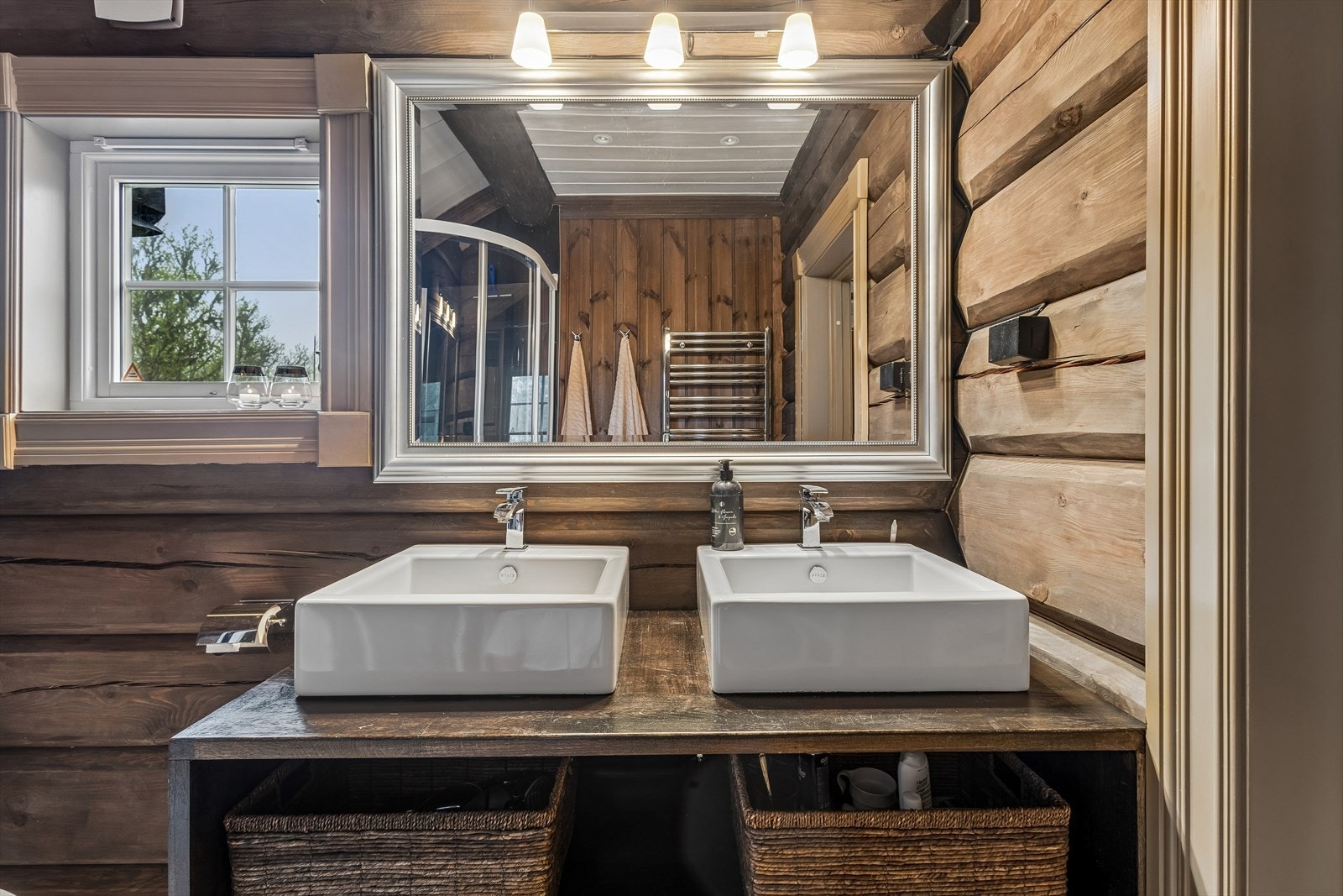 Badet er utstyrt med dusjkabinett, toalett og innredning i heltre, og har varmekabler i gulv. Galleribilde