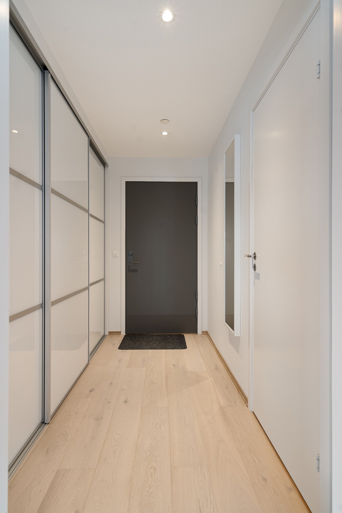 Entréen er utstyrt med en romslig skyvedørsgarderobe som gir svært gode oppbevaringsmuligheter og bidrar til et ryddig og praktisk inngangsparti. Galleribilde