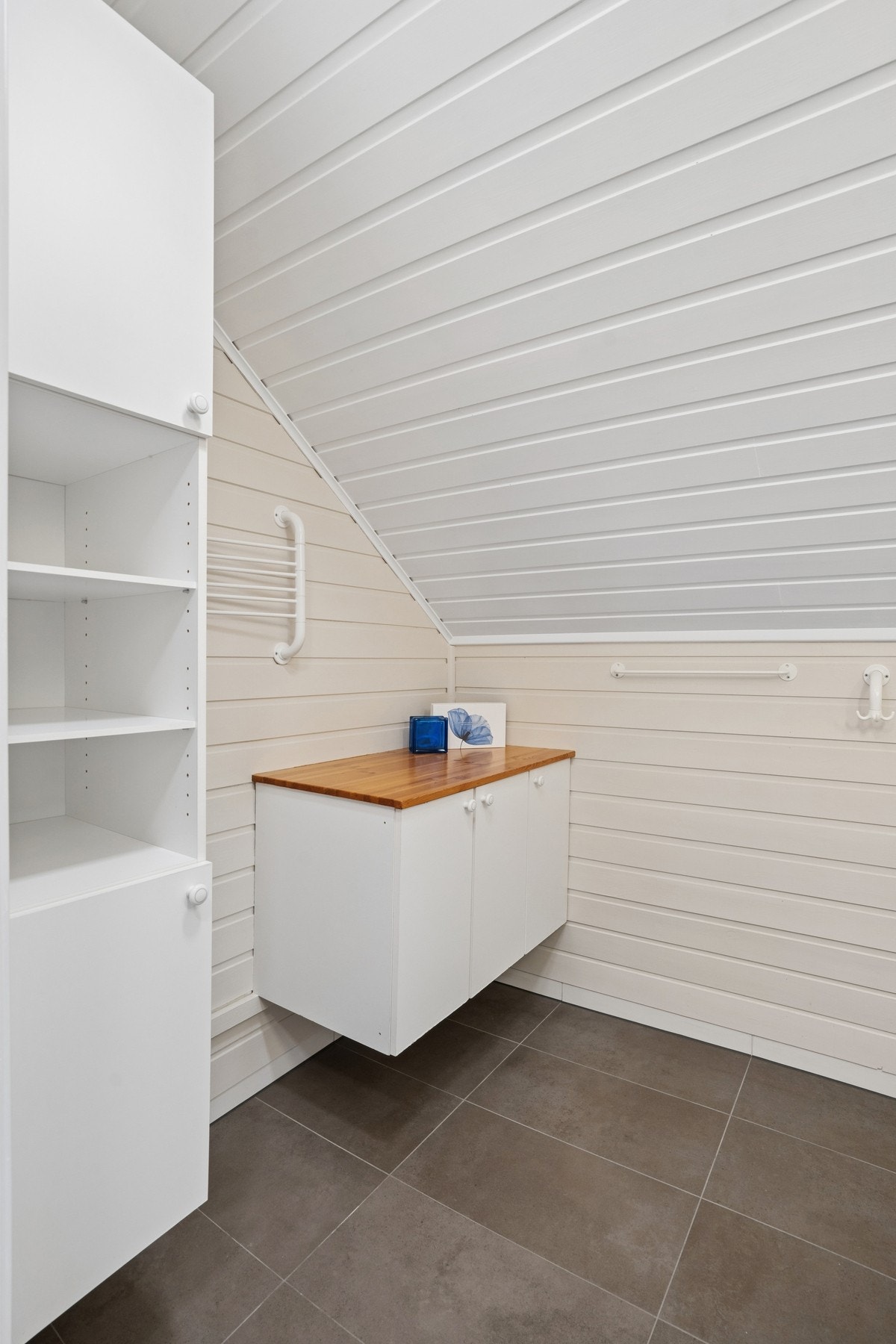 Badet har flislagt gulv med elektriske varmekabler og panel på vegger og i tak. Galleribilde