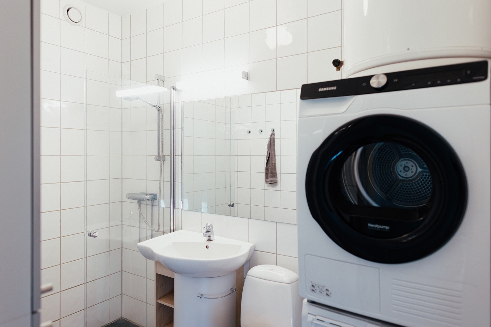 Flislag bad/wc/vaskerom med gulvvarme, wc, servant, speil og dusjhjørne. Selgers private foto
