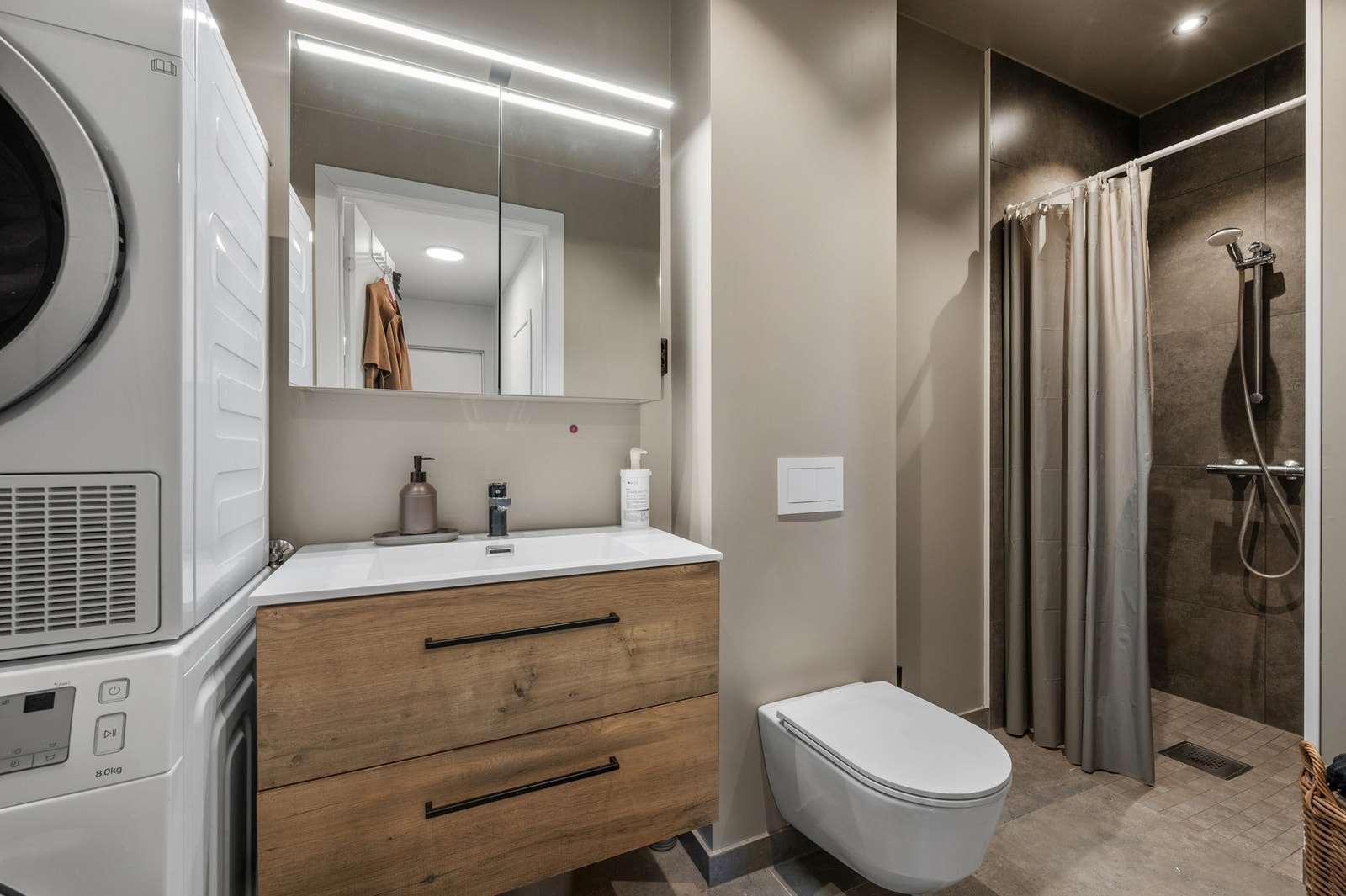 Utleiedelen - baderom på 5 m². Bad med dusj, servant og WC. Tilrettelagt for vaskemaskin og tørketrommel - smart utnyttet areal med alt nødvendig på ett sted. Galleribilde