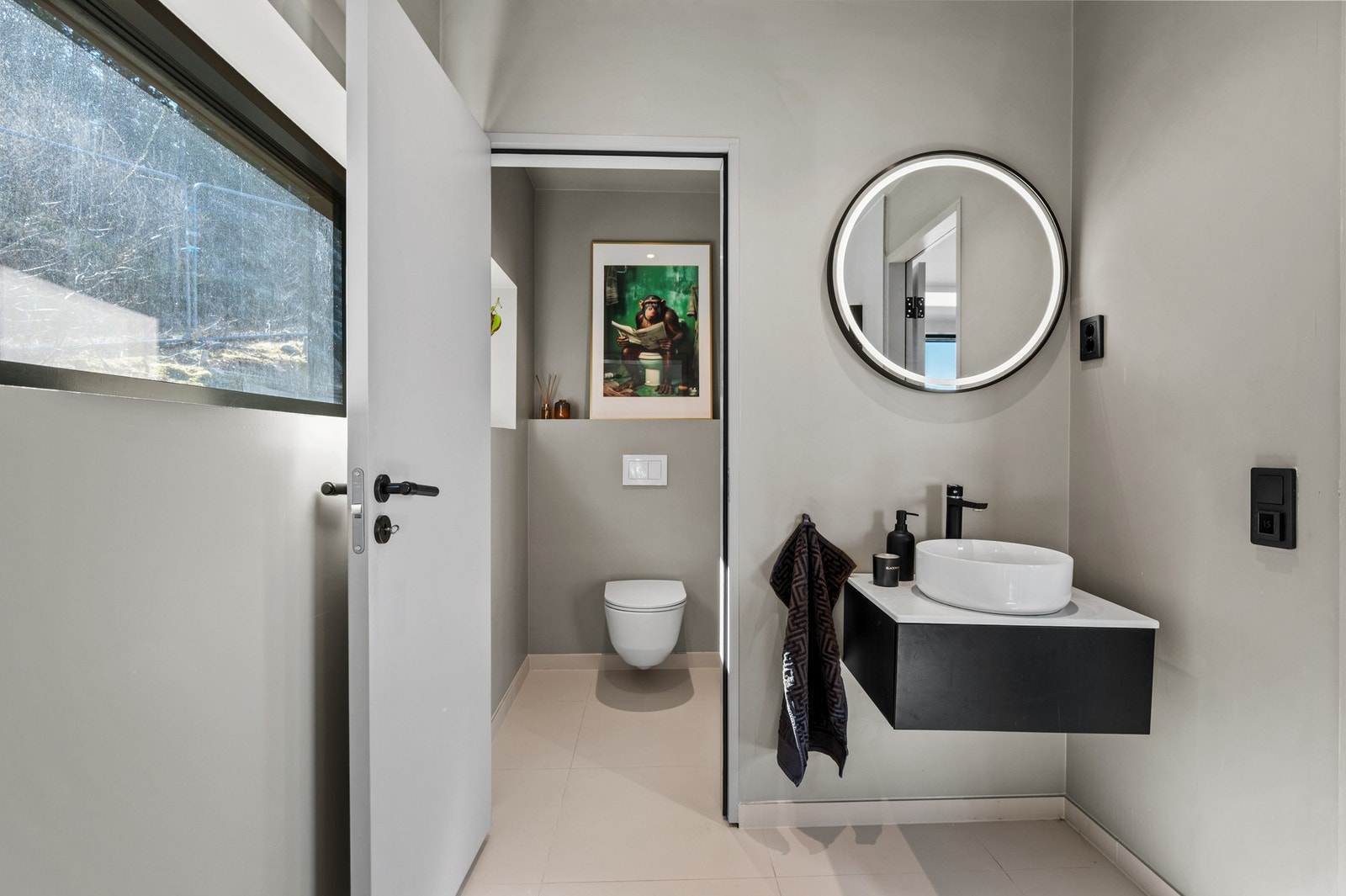 Bad 4 med adskilt toalettrom - stilrent gjeste-WC med hvit servant, Tapwell armaturer i kobber og rundt baklys-speil. Galleribilde