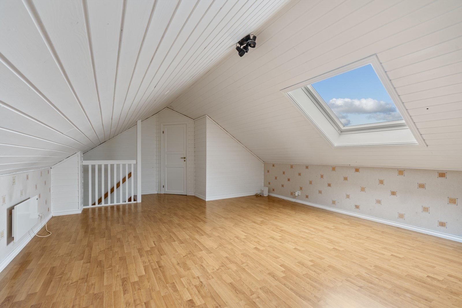 Loftstuen er et lyst og åpent rom med takvindu, som gir mange bruksmuligheter. Galleribilde